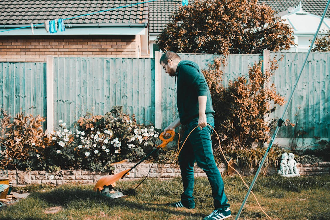Tuinman maait gazon met grasmaaier